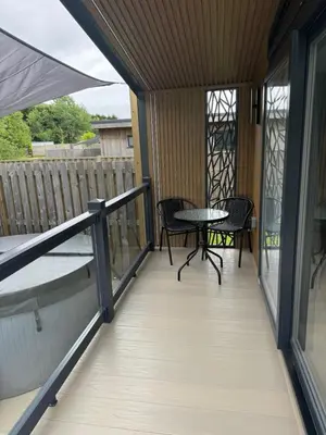 a screened porch with a table and chairs on it at luxury hot tub glamping apartment in Ireleth