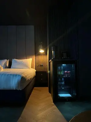 a bedroom with a bed and a drink refrigerator at Secret Suites in Lancaster