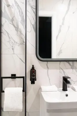 a white bathroom with a sink and a mirror at Secret Suites in Lancaster