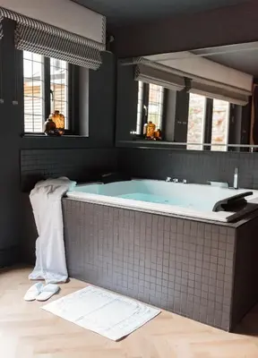 a bathroom with a blue tub with a mirror at Secret Suites in Lancaster