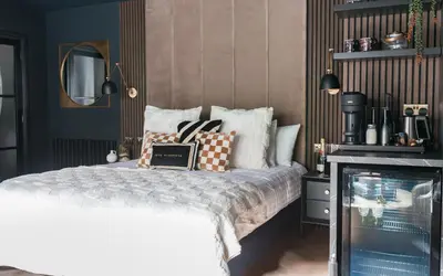 a bedroom with a bed with pillows and a tv at Secret Suites in Lancaster