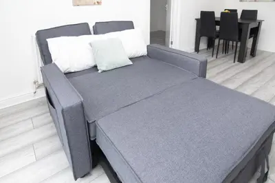 a large bed in a room with a table at Quiet 3 bed house, pet friendly in Kirkby