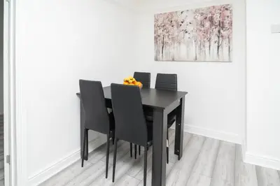 a dining room table with black chairs and a painting at Quiet 3 bed house, pet friendly in Kirkby