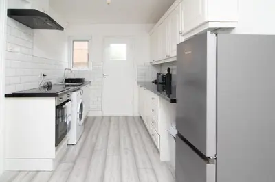 a kitchen with white cabinets and a refrigerator at Quiet 3 bed house, pet friendly in Kirkby