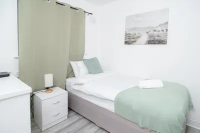 a white bedroom with a bed and a night stand at Quiet 3 bed house, pet friendly in Kirkby