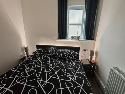 a bedroom with a black and white bed with a window at Lakeside View in Southport