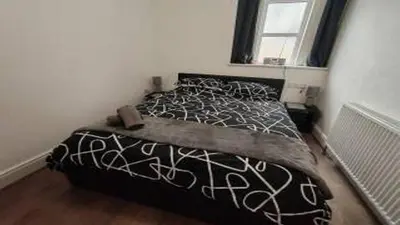 a bedroom with a black and white bed with a window at Lakeside View in Southport
