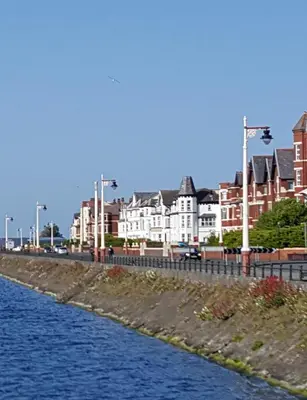 a river in a city with houses and buildings at Lakeside View in Southport