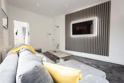 a living room with a couch and a tv at Cozy Boutique Studios Perfect for Contractors & Travelers in Bolton