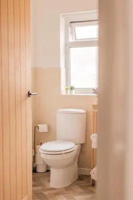 a white toilet in a bathroom with a window at Beautiful Home Away From Home - 3 Bedrooms - 6 Beds - Sleeps 7 - Free Parking in Liverpool
