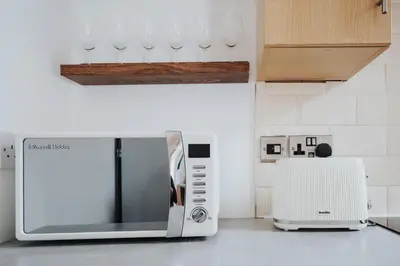 a microwave oven sitting on a kitchen counter at Beautiful Home Away From Home - 3 Bedrooms - 6 Beds - Sleeps 7 - Free Parking in Liverpool
