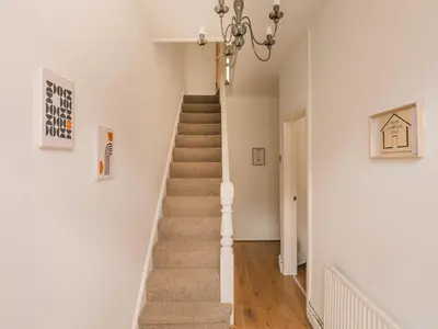 a staircase in a home with white walls and a chandelier at Beautiful Home Away From Home - 3 Bedrooms - 6 Beds - Sleeps 7 - Free Parking in Liverpool