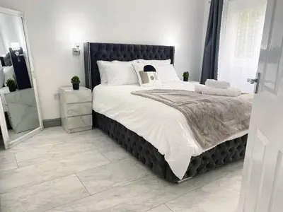 a bedroom with a large bed and a mirror at Modernised 3 Bed House in Liverpool