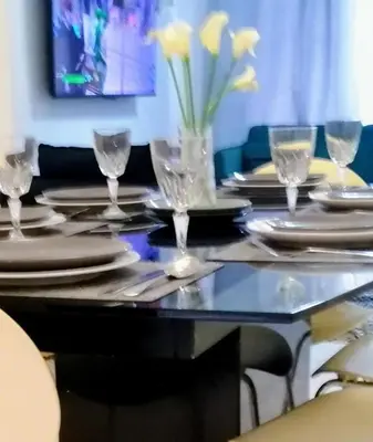 a table with plates and glasses and yellow flowers on it at Modernised 3 Bed House in Liverpool