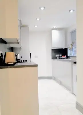 a kitchen with white cabinets and a counter top at Modernised 3 Bed House in Liverpool