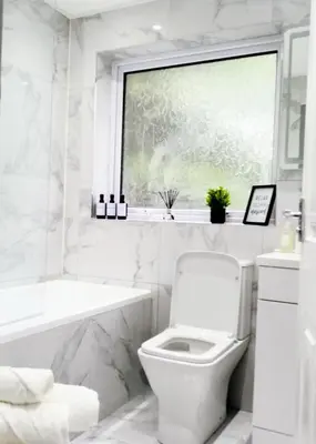 a white bathroom with a toilet and a window at Modernised 3 Bed House in Liverpool