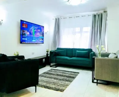 a living room with a couch and a flat screen tv at Modernised 3 Bed House in Liverpool