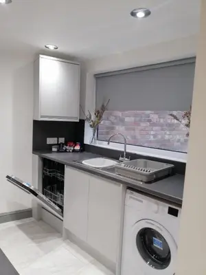 a kitchen with a sink and a washing machine at Modernised 3 Bed House in Liverpool