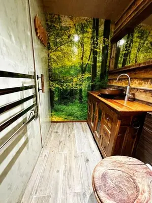 a bathroom with a sink and a window with a painting at Squirrel Hideaway with Hot Tub in Formby, Liverpool in Formby
