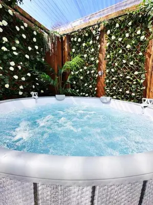 a jacuzzi tub in front of a plant at Squirrel Hideaway with Hot Tub in Formby, Liverpool in Formby