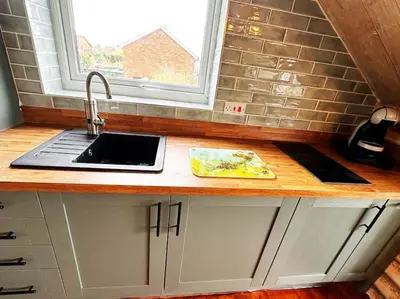 a kitchen counter with a sink and a window at Squirrel Hideaway with Hot Tub in Formby, Liverpool in Formby