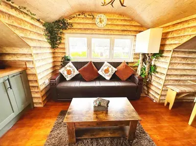 a living room with a leather couch and a table at Squirrel Hideaway with Hot Tub in Formby, Liverpool in Formby