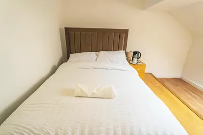 a large white bed with a white napkin on it at Majestic House Liverpool in Liverpool