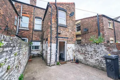 a brick building with a door in a courtyard at Majestic House Liverpool in Liverpool