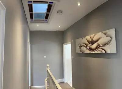 a hallway with a painting of a flower on the wall at Four Bedroom High Spec Victorian Townhouse in Clitheroe