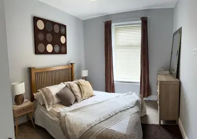 a bedroom with a bed and a window at Four Bedroom High Spec Victorian Townhouse in Clitheroe