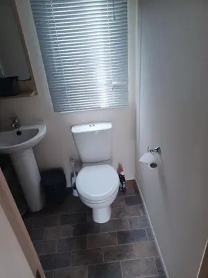 a bathroom with a white toilet and a sink at Ye Old'e Man - Sleeps 6 & Pet Friendly in Grange Over Sands