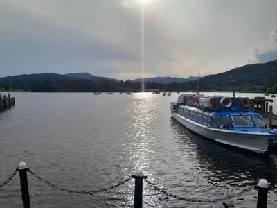 a boat is docked at a dock on a lake at Ye Old'e Man - Sleeps 6 & Pet Friendly in Grange Over Sands