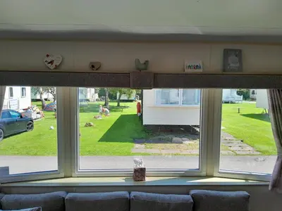 a window in a living room with a view of a yard at Ye Old'e Man - Sleeps 6 & Pet Friendly in Grange Over Sands