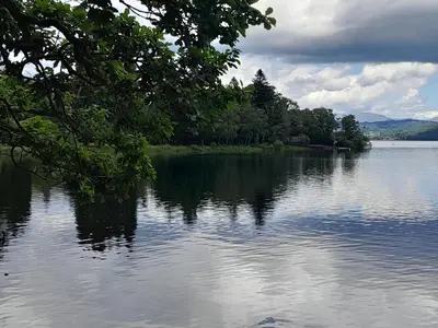 a large body of water with trees on the shore at Ye Old'e Man - Sleeps 6 & Pet Friendly in Grange Over Sands