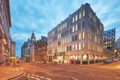 a building on a city street with a clock tower at 8 Water Street in Liverpool