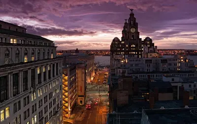 a view of a city at night with a clock tower at 8 Water Street in Liverpool