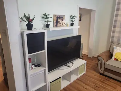 a living room with a flat screen tv on a white entertainment center at Comfy Home in Liverpool