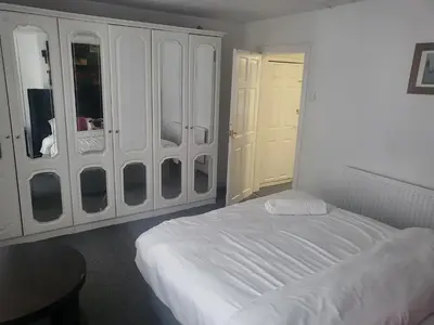 a white bedroom with a bed and a closet at Comfy Home in Liverpool