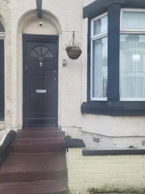 a black door on a house with a window at Comfy Home in Liverpool