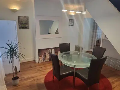 a dining room with a glass table and chairs at Comfy Home in Liverpool