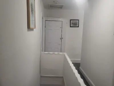 a hallway with white walls and a white door at Comfy Home in Liverpool