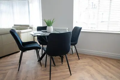 a dining room table and chairs with a plant on it at Gynn Stays - Apartment One in Blackpool