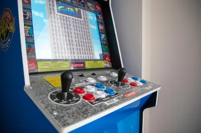 a video game machine with controllers and a screen at Gynn Stays - Apartment One in Blackpool