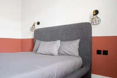 a bed in a room with two lights on the wall at Gynn Stays - Apartment One in Blackpool