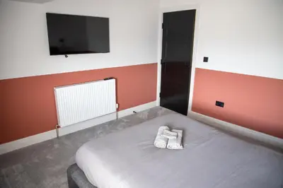 a bed with two white shoes sitting on it in a room at Gynn Stays - Apartment Two in Blackpool
