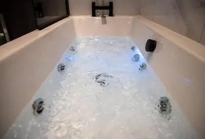 a bath tub filled with lots of water at Gynn Stays - Apartment Two in Blackpool