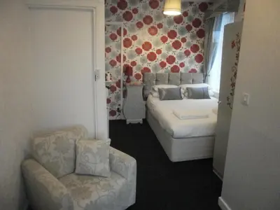 a bedroom with a bed and a couch and a chair at The Withnell Hotel in Blackpool