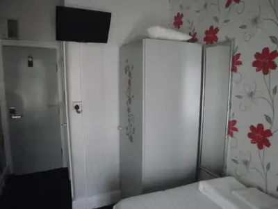 a bedroom with a white cabinet with flowers on the wall at The Withnell Hotel in Blackpool