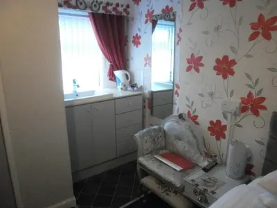a kitchen with a chair and flowers on the wall at The Withnell Hotel in Blackpool