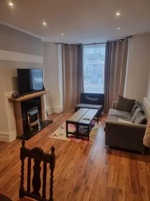 a living room with a couch and a table at Fir Trees in Blackpool